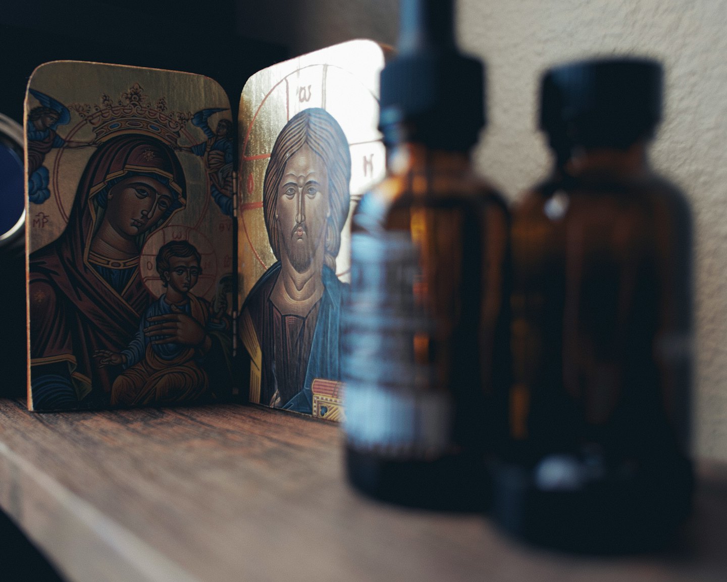 Painted religious icon rests on a rustic wooden surface.