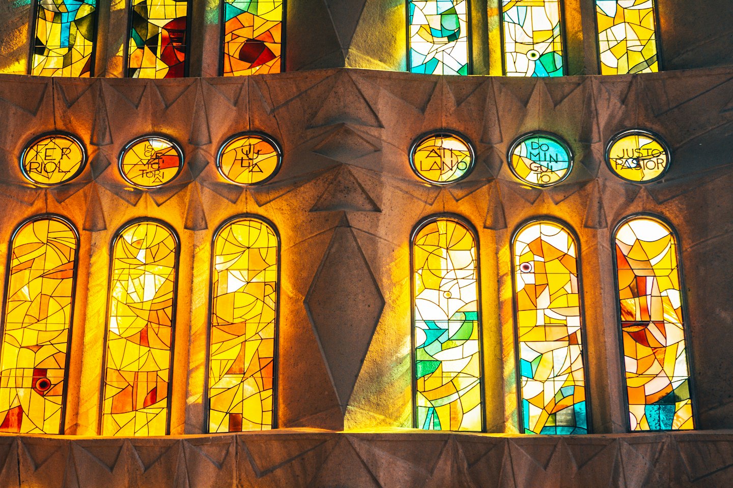 Sunlight streaming through colorful abstract stained glass windows.