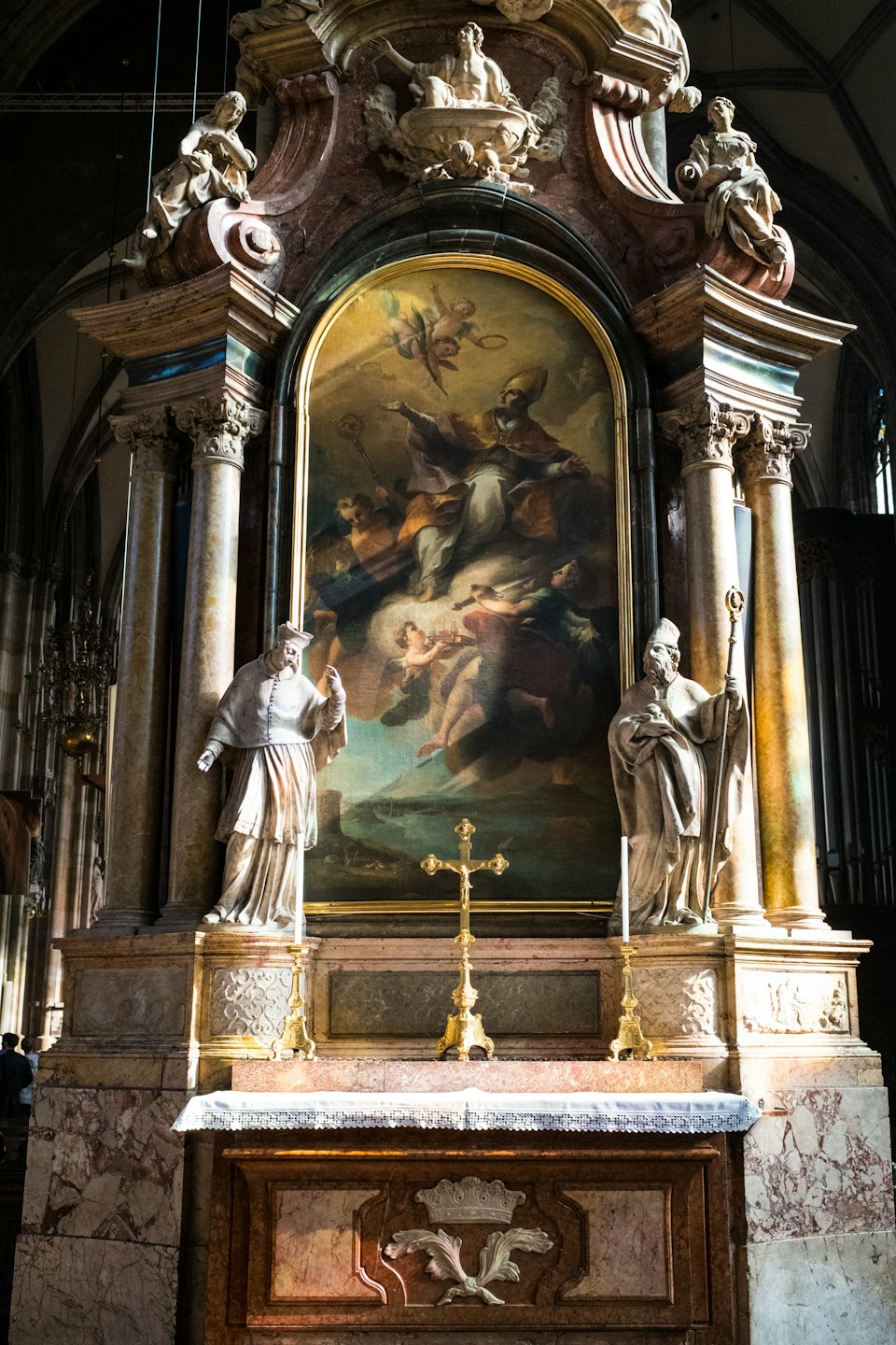 Ornate church altar with religious painting and stone statues.